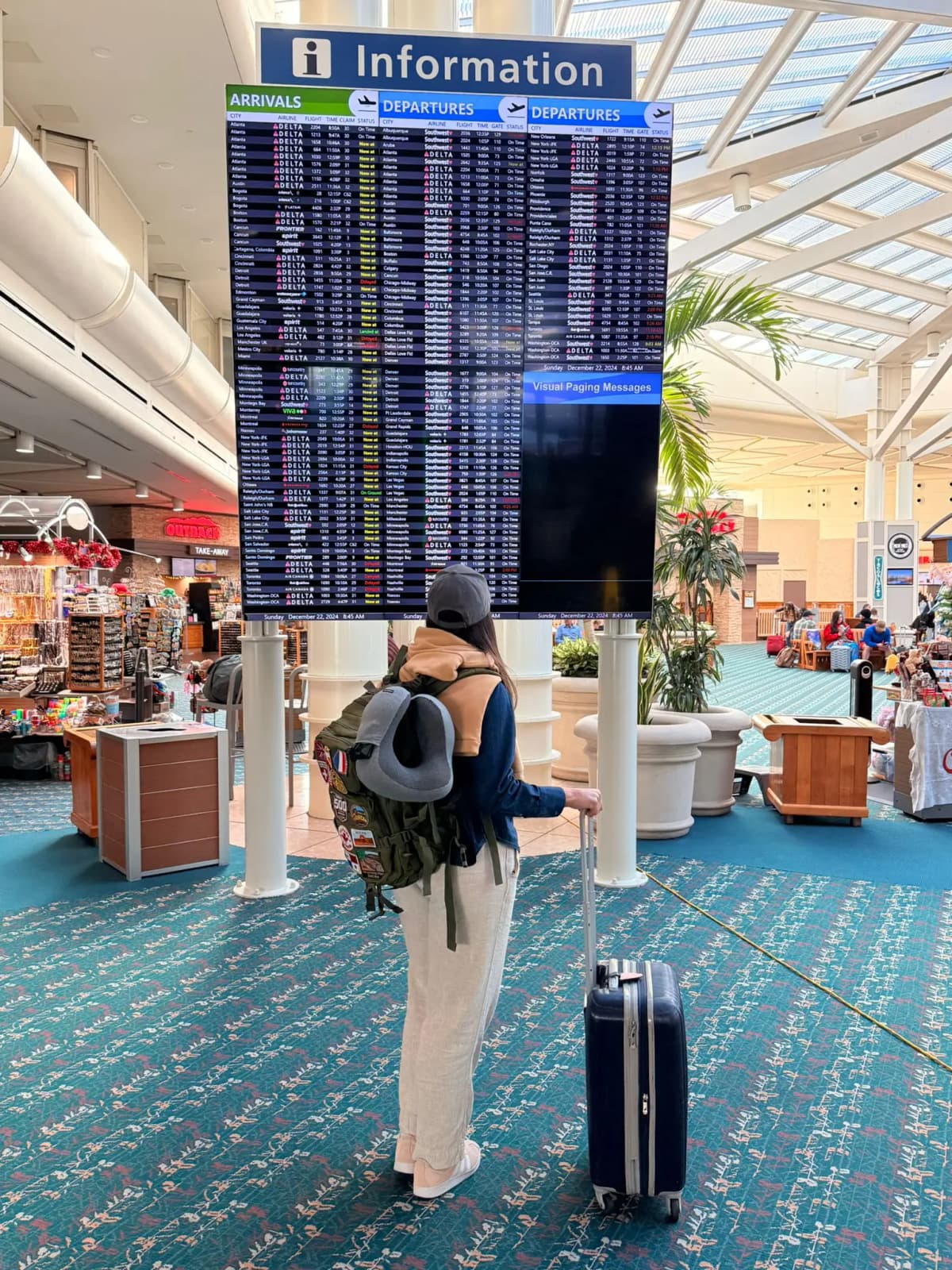 Mulher olhando painel de informações de voo no aeroporto